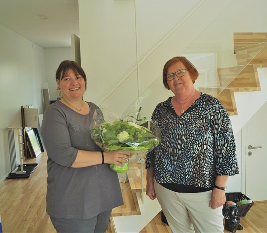 Astrid giver blomster til beboer i Robinielunden